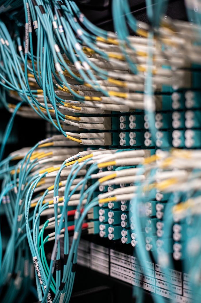 digital Rows of blue cables and wires plugged into server patch panel located in modern data center framework
